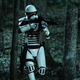 Three white-armored Commonwealth soldiers tread carefully through a darkened forest with their rifles ready.